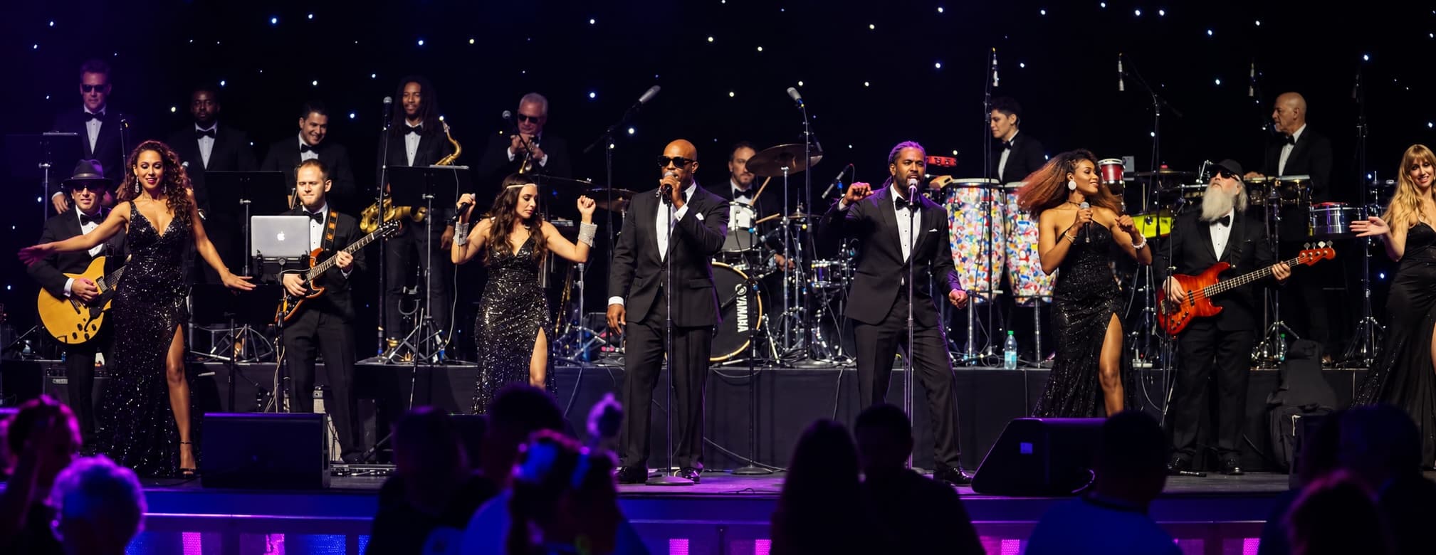 The de Bois All-Stars performing on a stage edged with white and blush florals