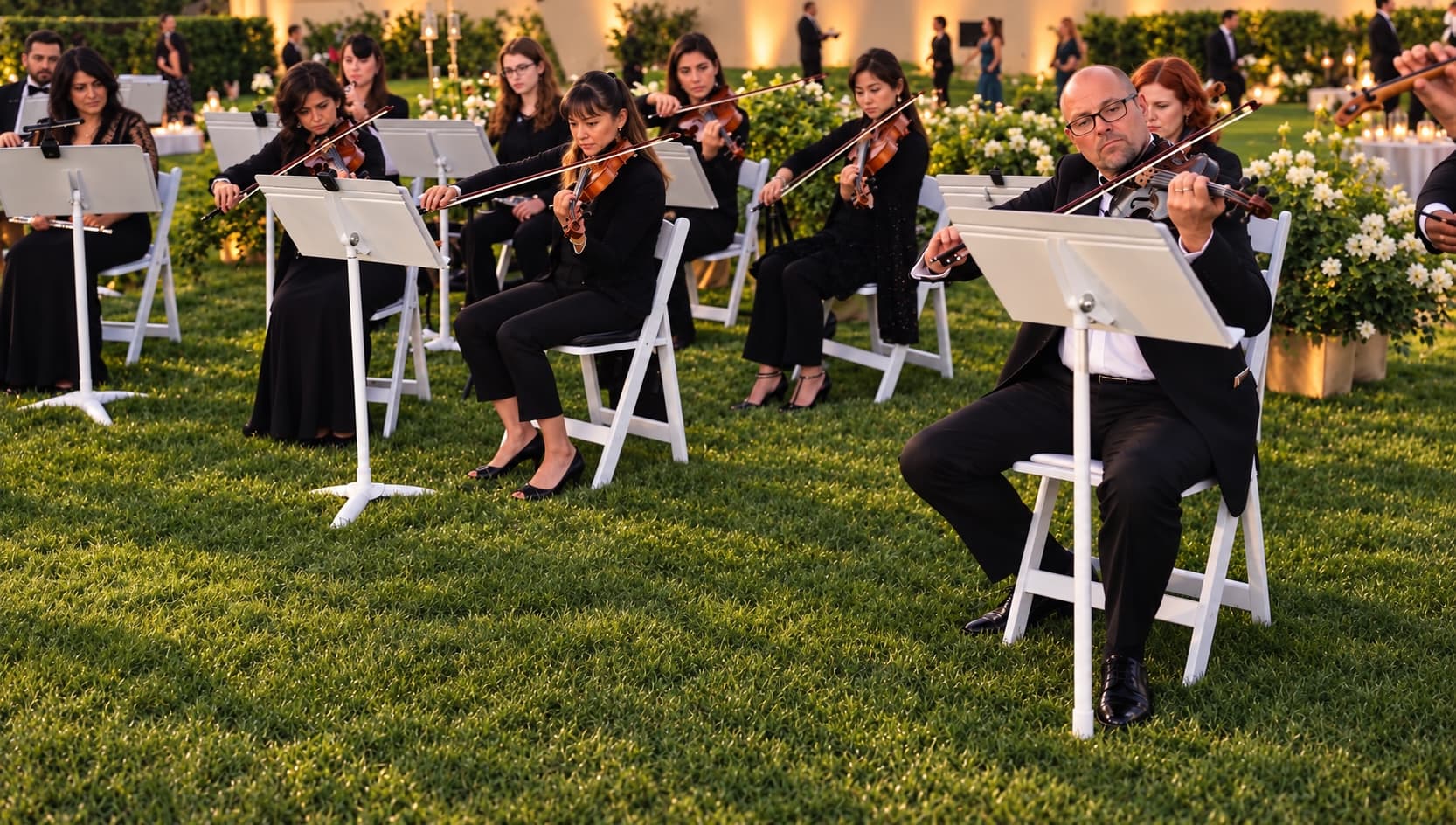 A string section performing, violins and cellos in soft light
